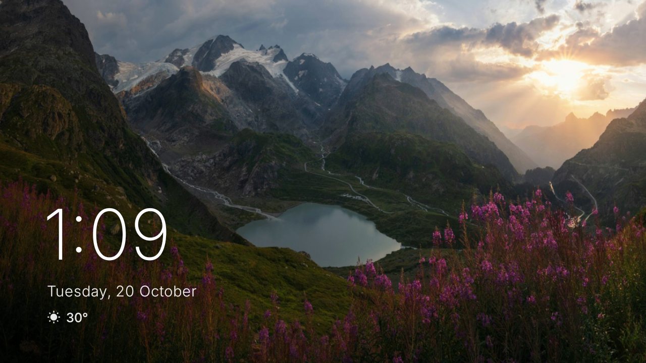 The cleanOS screensaver: the mountain lake wallpaper fills the screen with a large thin clock, the date and the temperature at bottom left.